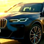 夕日を背にしたBMW X7の高級SUV、堂々たるフロントグリルと洗練されたボディラインが特徴