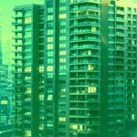 夜の都市部に立ち並ぶ高層マンションとビル群の外観